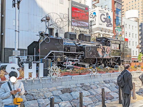 新橋駅前広場の蒸気機関車の前で記念撮影