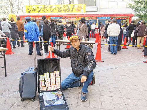 大阪駅前第四ビル特設売場の前で今日買った年末ジャンボ宝くじをバックに詰めて記念撮影
